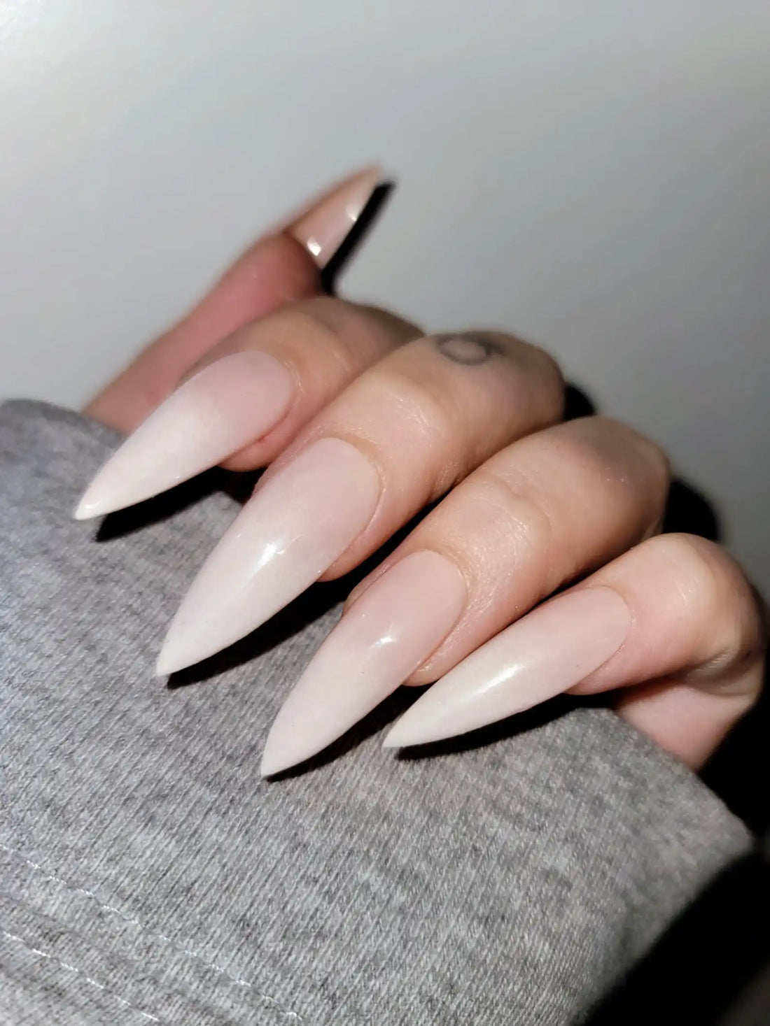 Hand with long stiletto pastel French tip handmade press-on nails
