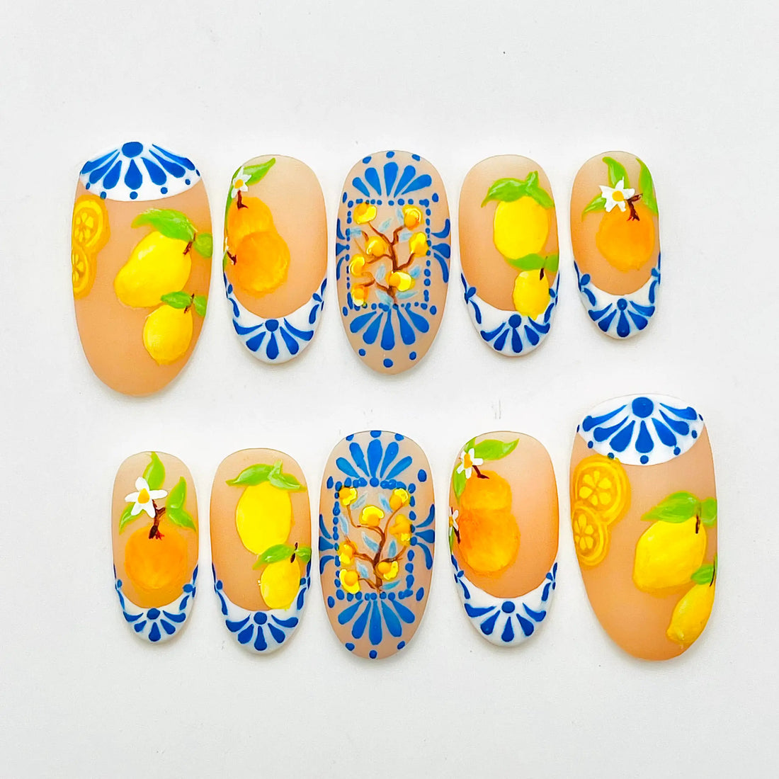 Handmade press-on nails with orange and lemon fruit design, blue and white summer accents