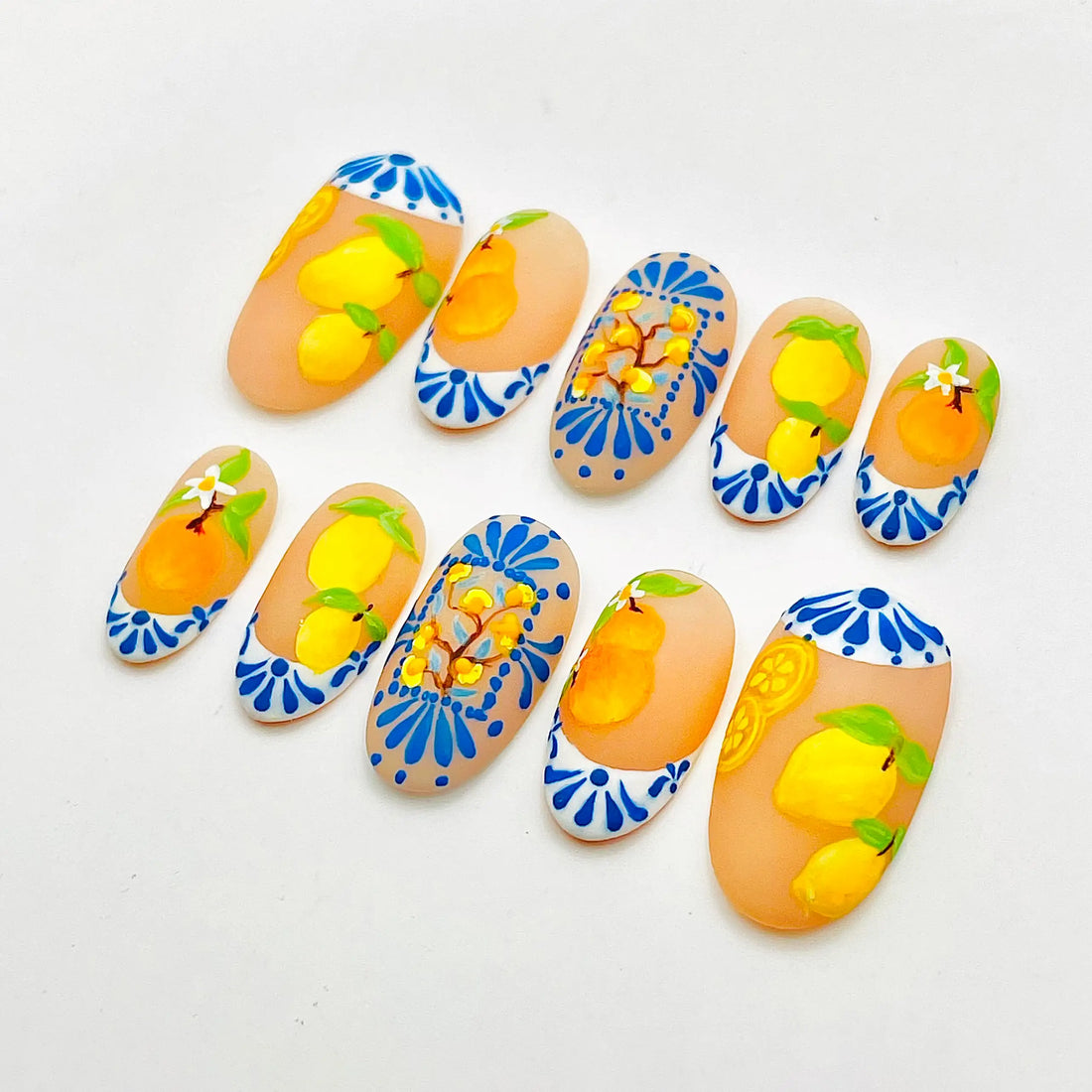 Handmade press-on nails with orange and lemon fruit design, blue and white summer accents