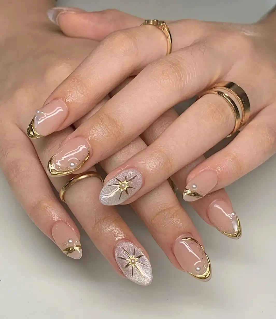 Shimmery pearl gold custom handmade press-on nails with star accents and metallic tips