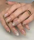 Handmade press-on nails with pearl gold tips and starburst accent design