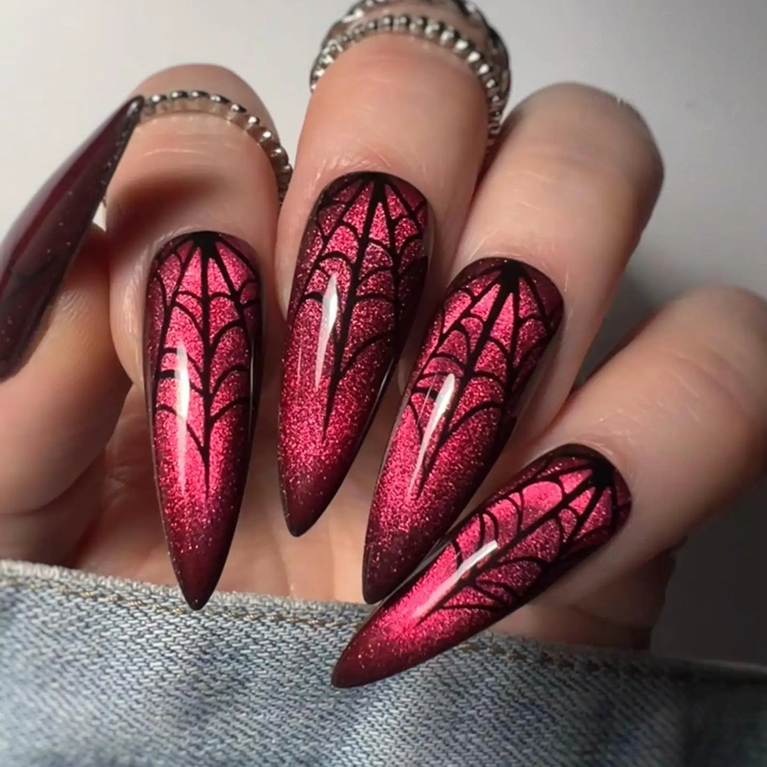 Red velvet cat eye press-on nails with black spider web Halloween nail art design