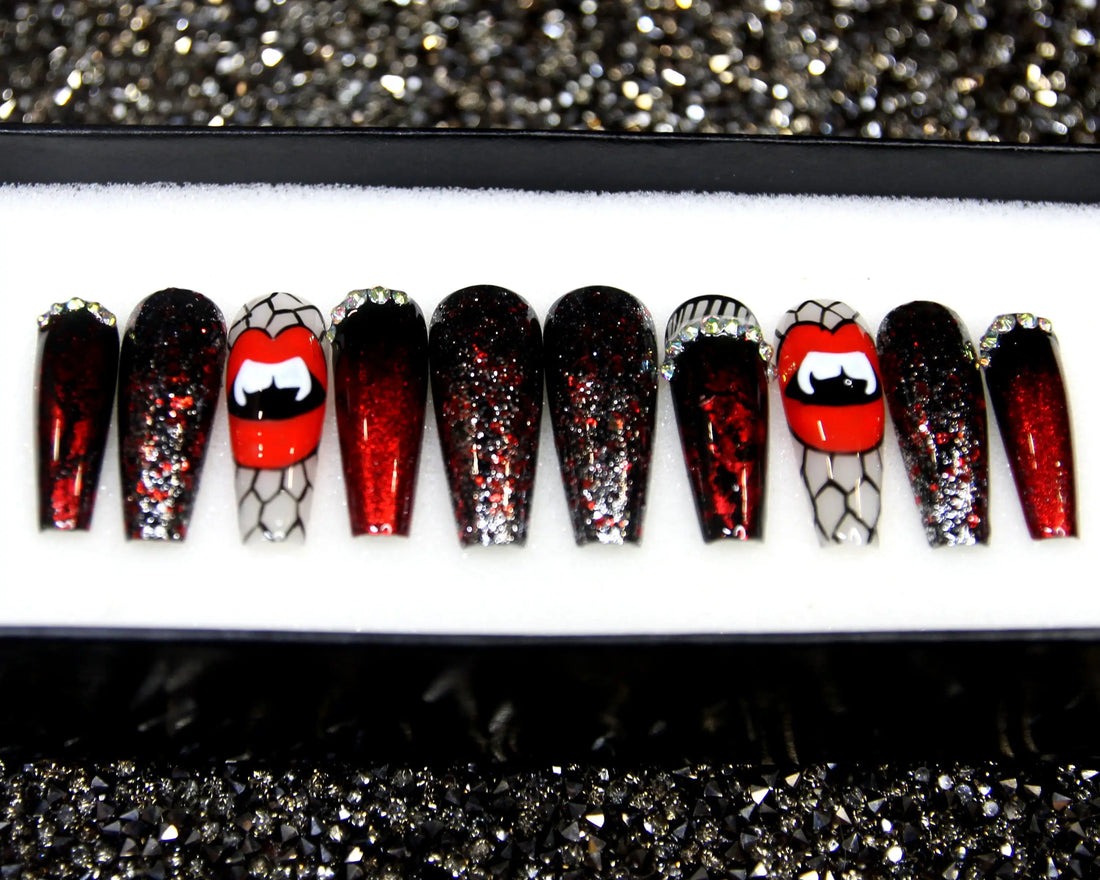 Halloween press-on nails with red glitter, vampire lips, and spider web designs displayed in a box
