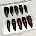 Red and black ombre stiletto Halloween press-on nails with silver cross embellishments.
