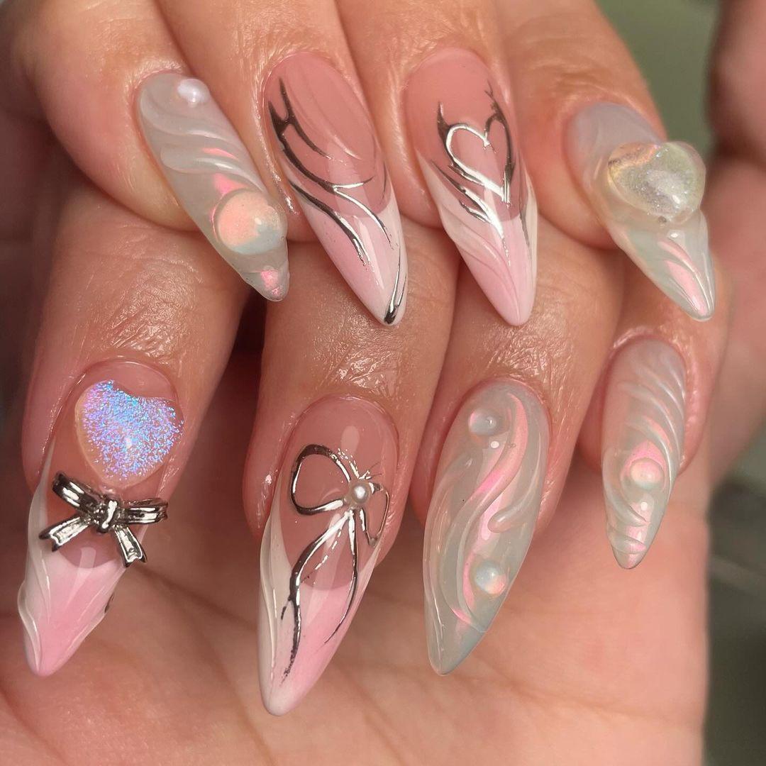 Long stiletto press-on nails with pink, white, and silver heart, bow, pearl, and 3D accents
