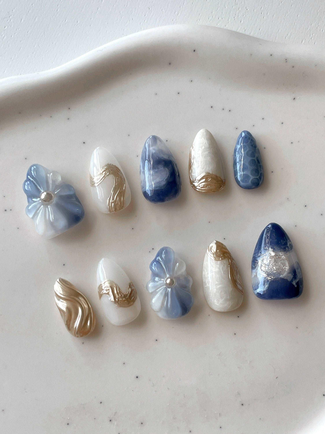 Blue and white handmade press-on nails with gold accents and 3D floral designs