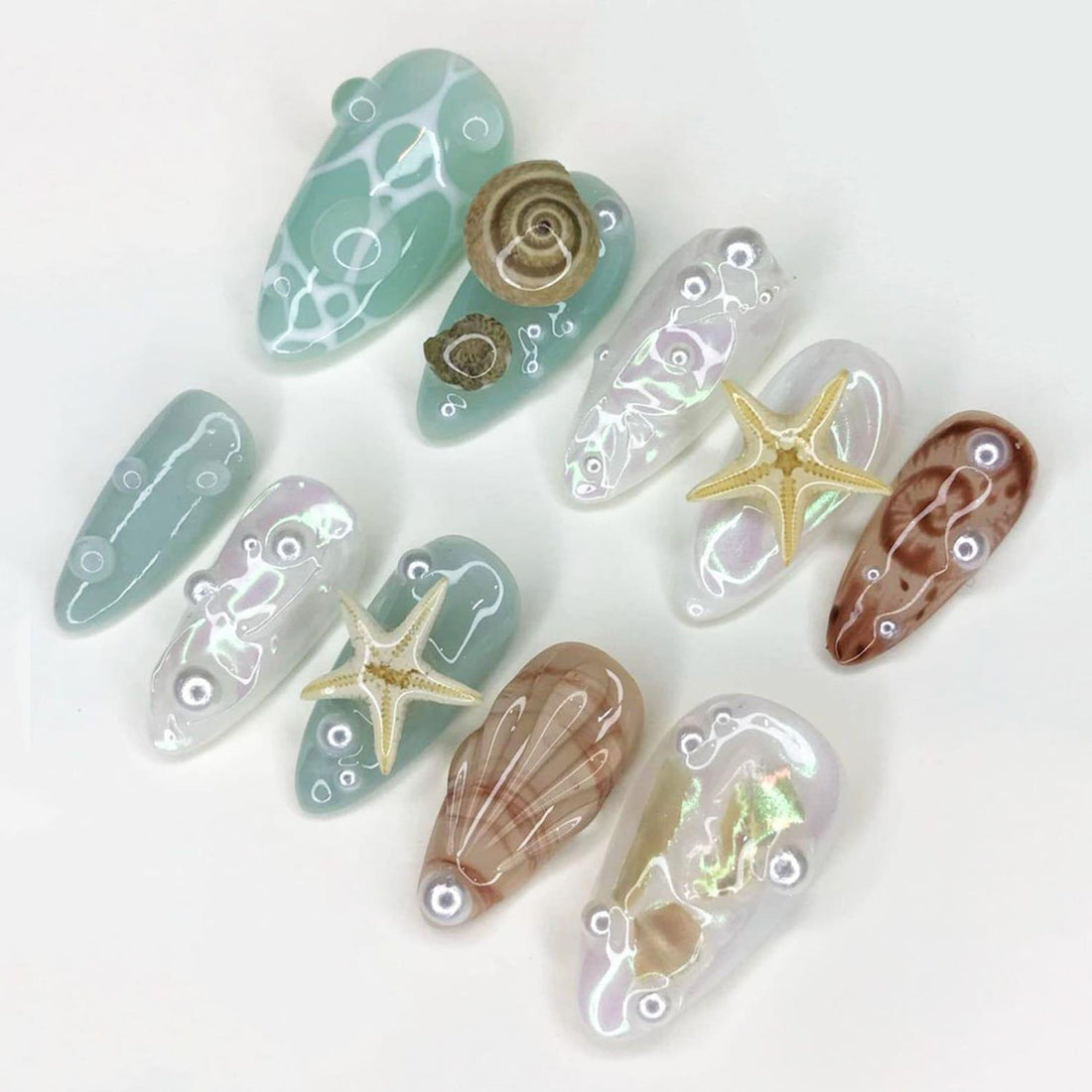 Handmade reusable press-on nails with sea shell, starfish, and ocean-inspired designs.