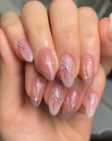 Pink press-on nails with silver bow designs and glitter accents, almond shape manicure