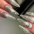 Long stiletto press-on nails with silver shimmer and white snowflake design