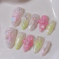 Handmade pastel press-on nails with 3D flowers, pearls, and heart accents on a white background